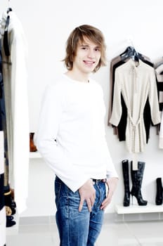 man in shop of clothes, smiles and is happy with purchases