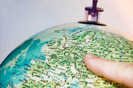 Finger pointing on a globus with german letters