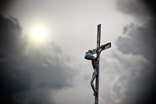 Cross with jeus in front of dark clouds