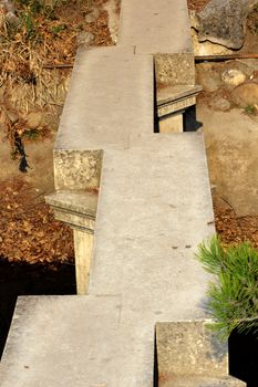 japanese style bridge made of stone in a botanical garden