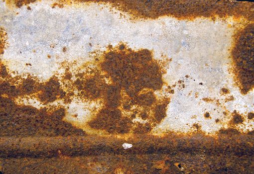 Background of ancient cracked rusty tin wall. Tin corroded wall fragment backdrop.