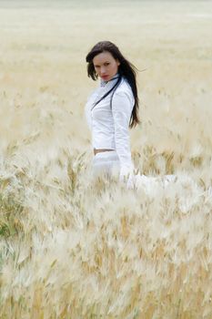 Sexy, young woman dancing in a field of wheat