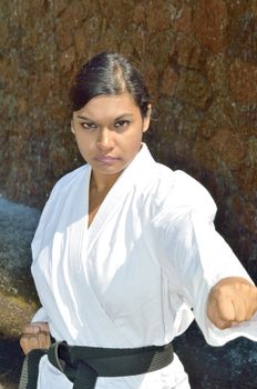 Female black belt champion karate player demonstrating various karate moves in the park