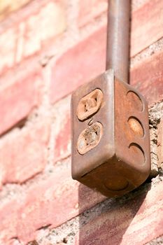 Rusted plug on outside of building.