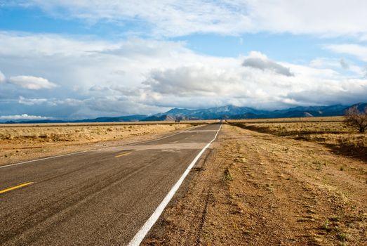 Road through desert in winter storm