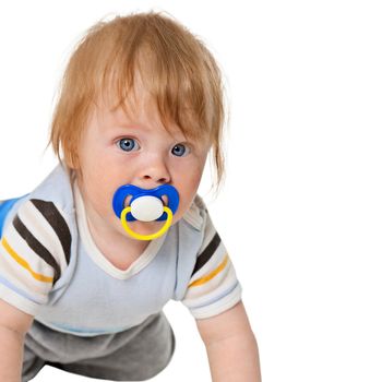 Portrait of attentive baby with a pacifier in his mouth