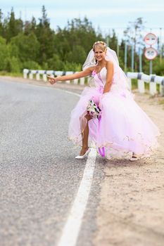 Lonely bride hitching on a suburban road