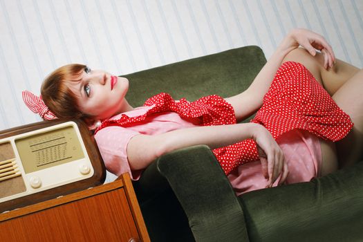 Old-fashioned young woman listening to the radio