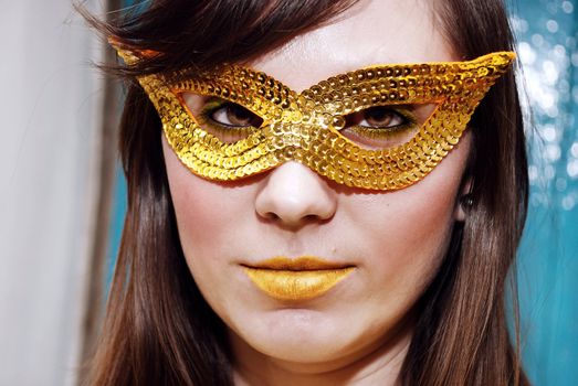 Close-up portrait of a beautiful brunette in a masquerade mask.