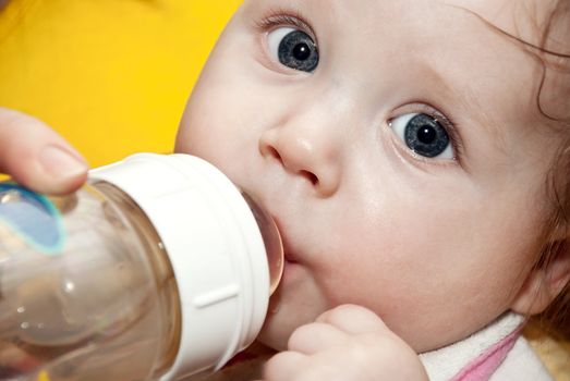 Little boy drinking juice from a bottle. Close-up.
