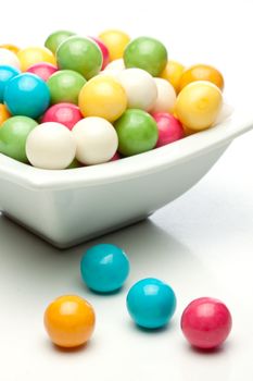 many colored gumballs on a white background