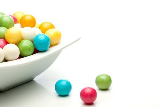 many colored gumballs on a white background