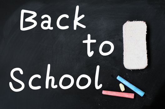 Back to School written on a chalkboard, with eraser and chalk
