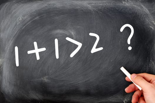 One plus one is greater than two. Question written on a blackboard.