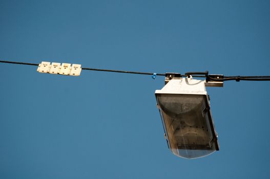 street light hanging above a street with great blue sky