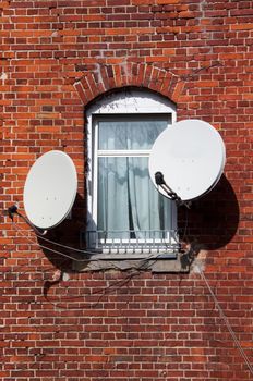 TV - window on the world: satellites and window on brick wall