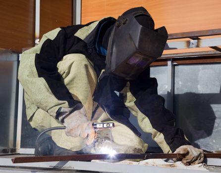 Welder in a special suit, while working in direct sunlight