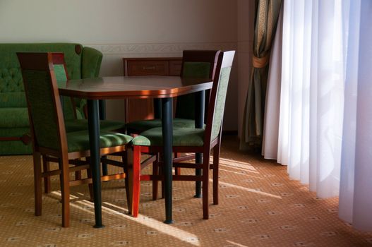 Room decorated in classical style with wooden table and chairs