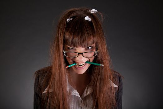 Angry businesswoman with broken pencil, studio shot 