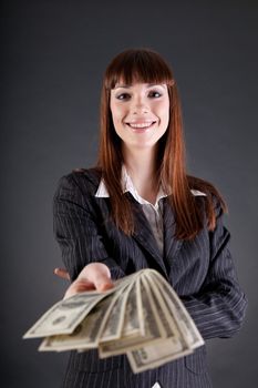 Cheerful business woman with dollars offering credit, studio shot 