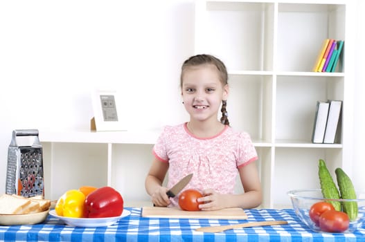 beautiful young girl cooking vegetables for a salad, working in kitchen