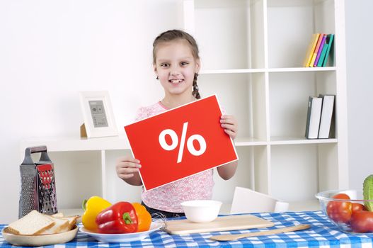 Young child cooking fresh meal at home and holding procent sign