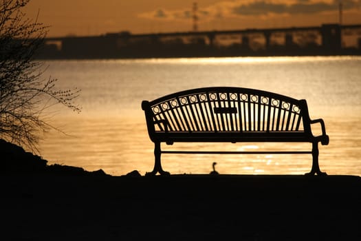 Sunrise with park bench with harbour view