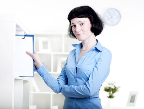 woman puts a tablet with documents in a rack for documents