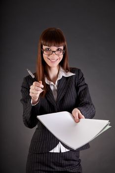 Cheerful businesswoman with documents and pen, studio shot on black background 