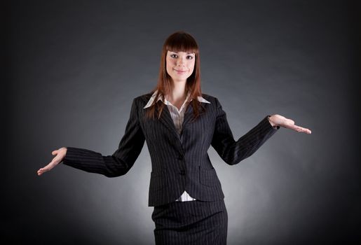 Cheerful business woman showing open hands, studio shot 