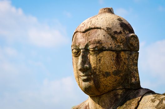 Ancient Buddha head with blue sky on background