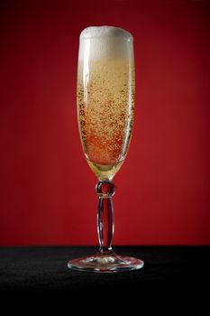 Champagne glass over red background 