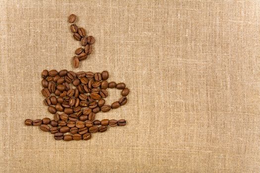 Coffee cup made of beans over canvas background, lot of copy-space 