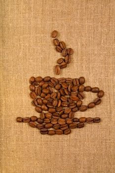 Coffee cup made of beans over light canvas background 