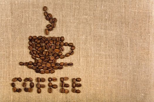 Coffee cup made of beans over canvas background 