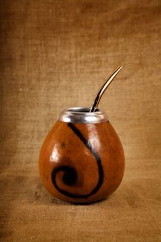 Argentinean Calabash cup with Bombilla over canvas background, selective focus 