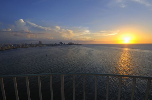 Havana bay entrance and city skyline at dusk with sun setting