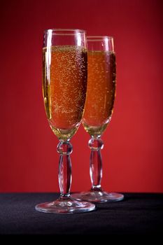 Champagne glasses over red background, selective focus 