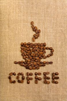 Coffee cup made of beans over canvas background 