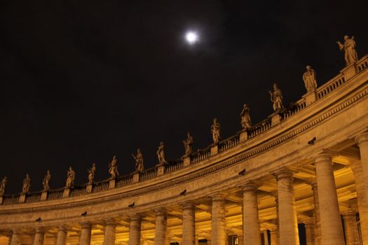 The colonnade in Saint Peter's Square, in Vatican City, at night.
