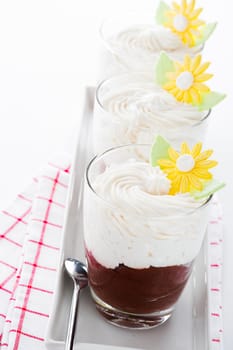 A glass with mousse au chocolat and whipped cream on white background as a studio shot