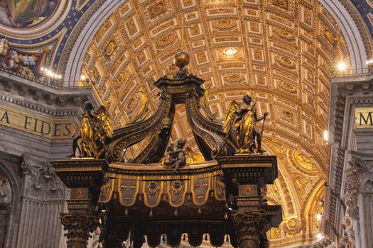 The dome of St. Peter's Basilica with the top of the baldachin in the bottom of the frame.
