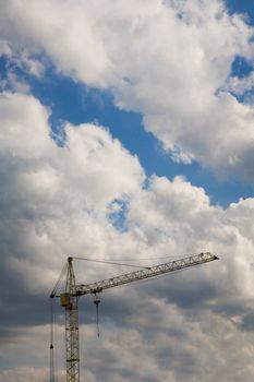 Construction crane over cloudy sky  