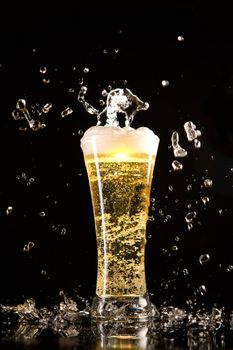 Beer glass with water splashes, isolated on black background