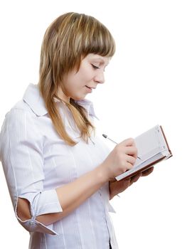 young girl in a white blouse writes in a notebook
