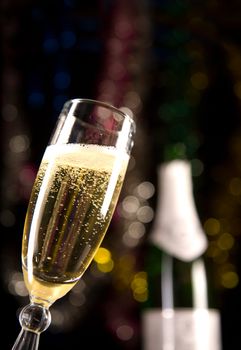 Close-up of champagne glass, blurred bottle on background