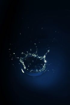 Water splash over dark blue background 