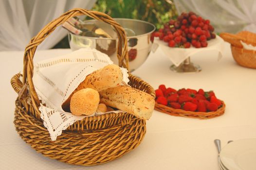 Table setting with bread basket and wine bottles on background