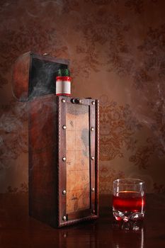 Still life with cognac glass and bottle in box