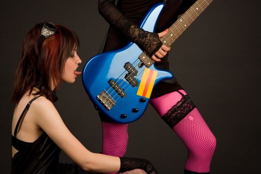 Two girls with bass guitar, one of them licking it